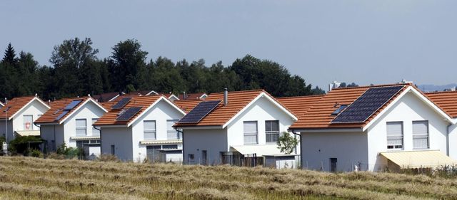 Una hilera de casas con paneles solares en los techos